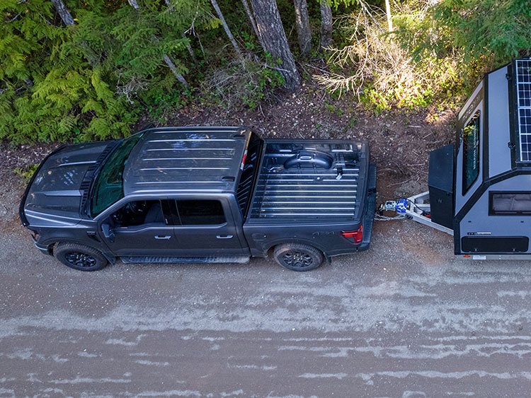 Ford F-150 towing a Reboot 19.6 overland trailer on a gravel road
